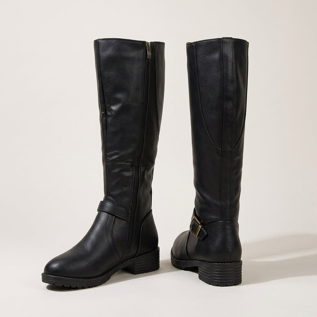 A pair of black leather knee-high boots with side zippers and buckle details, shown from the front and side angles on a light beige studio background.